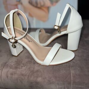 White Block heels with dangly rhinestone.